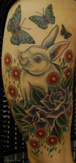 The rabbit in this tattoo are surrounded by other symbols of spring and new life; flowers and butterflies
