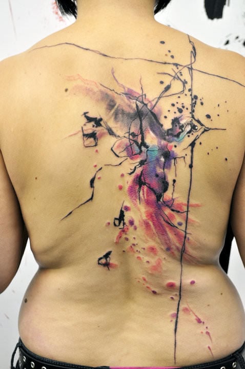 A bird frolics in the painterly effect of this Musa tattoo