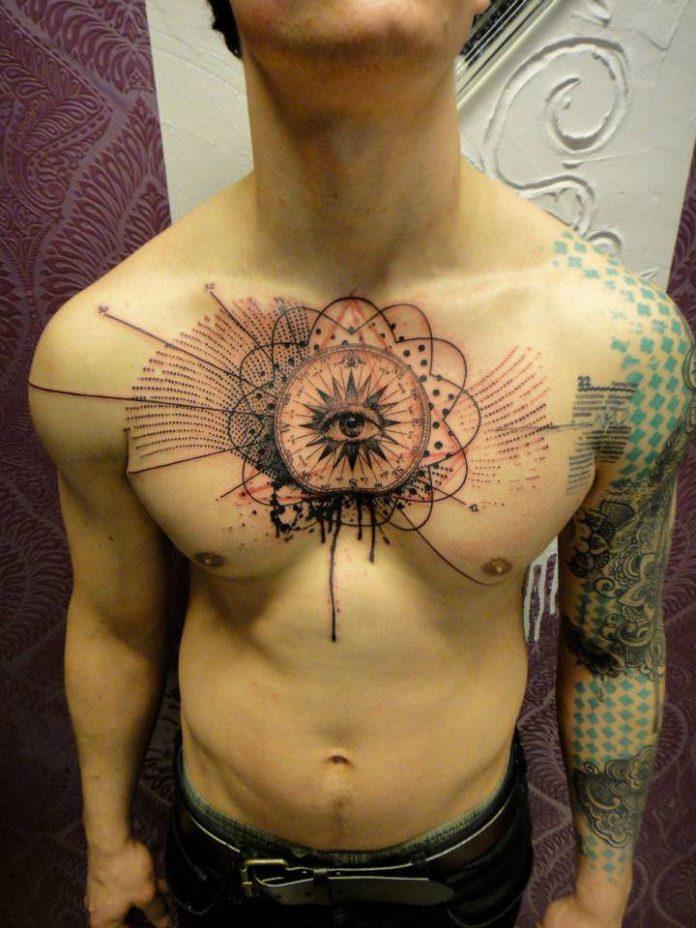 A human eye stares out from a mandala on this guys chest in an abstract tattoo by Xoil
