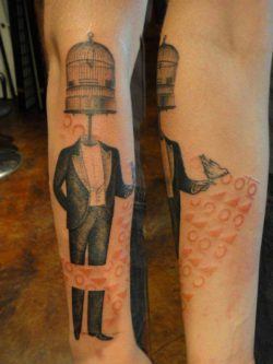 A man with a bird cage for a head poses in this artistic mixed media tattoo by Xoil
