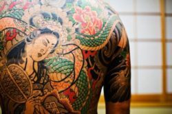 A yakuza tattoo that depicts a geisha figure. The traditional hand poking method of tattooing is very painful