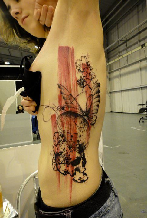 Streaks of paint finish off this artistic abstract tattoo by Xoil
