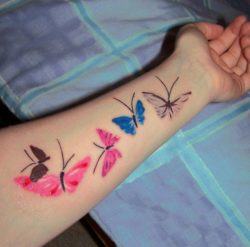 A scattering of painted butterflies makes for a fun, artistic tattoo design