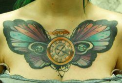 A pocket watch and human eyes add symbolism to this butterfly chest tattoo by Jukan
