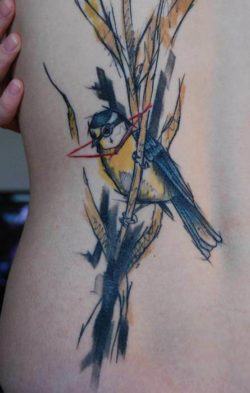 A watercolor painting becomes an abstract body art work in this tattoo of a bird on a reed by Sven Groenewald