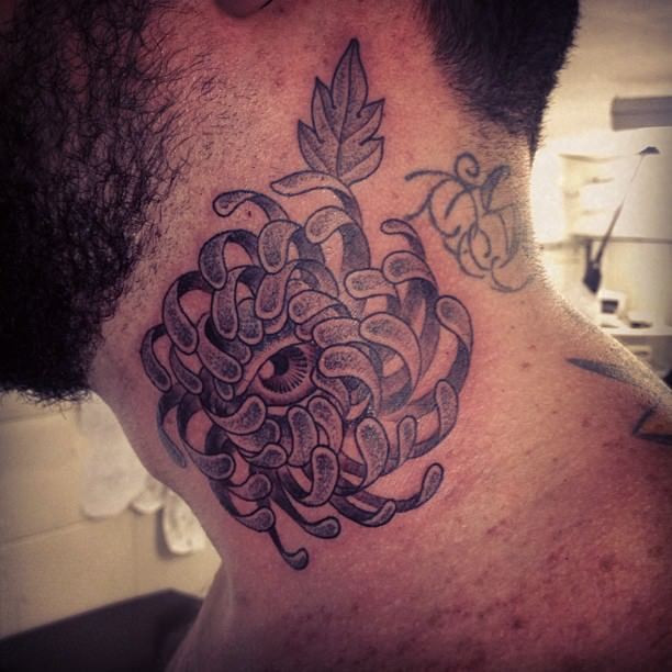An eye peeks out of the heart of a flower in this dot work tattoo by Gregorio Marangoni