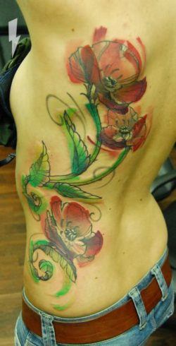 Berlin tattoo artist Jukan creates a beautiful watercolor tattoo of poppy flowers