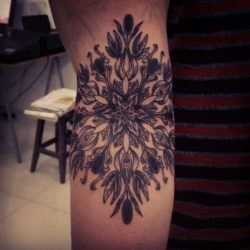 Gregorio Marangoni uses lines and tiny dots to create this beautiful mandala flower tattoo