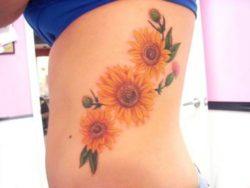 Sunflowers and thistles make up this bright and colorful flower tattoo design
