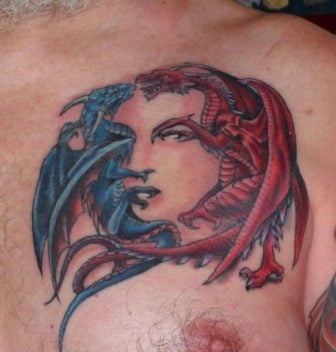 The two dragons fighting in this tattoo design are positioned perfectly to form the features of a womans face