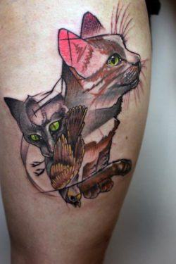 This abstract illustration tattoo shows two cats and a bird, their favorite prey