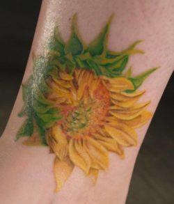 This artistic sunflower tattoo shows how the petals of the flower unravel from the heart outwards