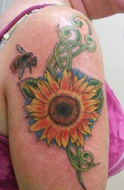 This sunflower tattoo design has a bee hovering nearby. Both are symbols of life and fertility