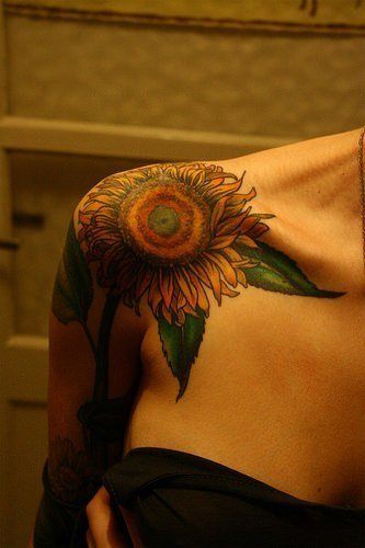 This sunflower tattoo is placed on the round bone of the shoulder, accentuating that area of the body