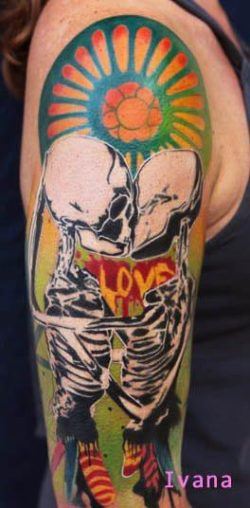 Two skeletons kiss in front of the word LOVE in this artistic tattoo by Ivana Belakova