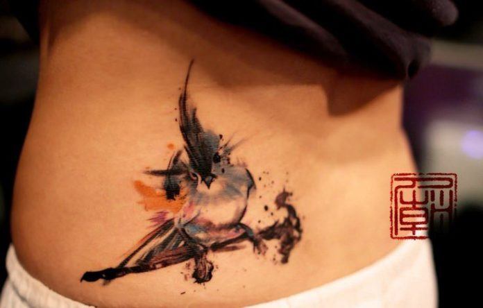 A little bird explodes with life and color in this abstract tattoo from hong Kong studio Tattoo Temple