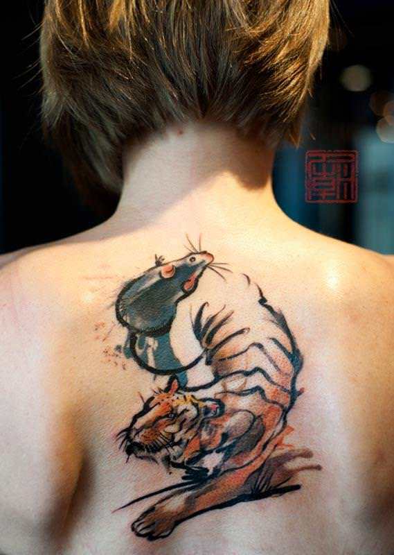 A mouse and a tiger dance together in this Abstract tattoo from the Hong Kong studio Tattoo Temple