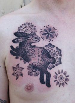 Spanish tattoo artist Gemma Pariente combines dotwork textures and gradients in this bunny rabbit and flowers tattoo