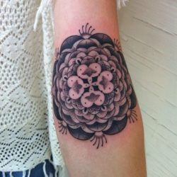 This feminine mandala flower tattoo by Gemma Pariente boasts her signature dot work and gradient textures