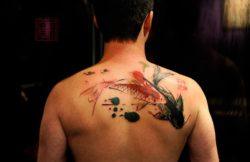 Two koi fish get a modern design style in this artistic abstract tattoo from Tattoo Temple studio in Hong Kong