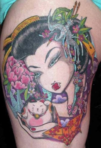 A beautiful geisha is surrounded by flowers, birds and lucky symbols in this tattoo by Venus Flytrap