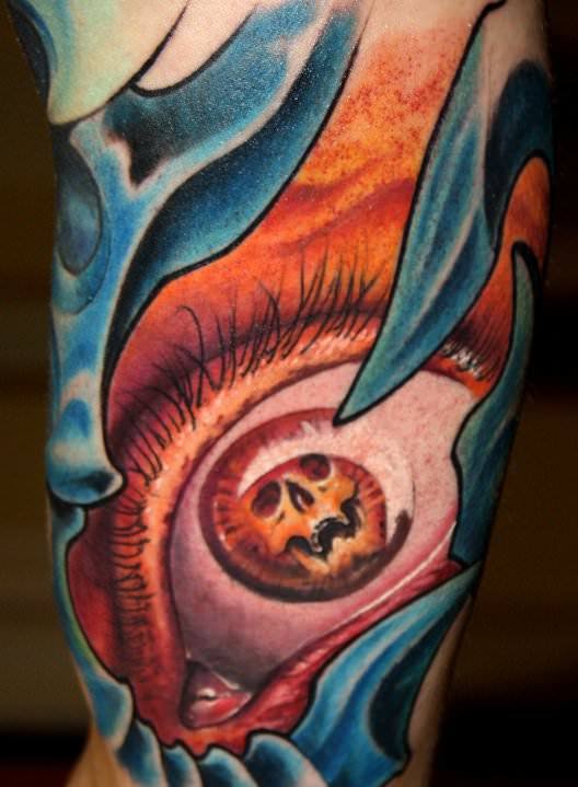 A skull grins out of a woman eye in this surrealist tattoo design by Austrian tattoo sudio Nadelwerk