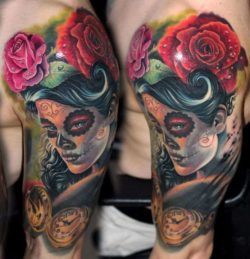 A woman wears sugar skull make-up in this photo realistic portrait tattoo by Nadelwerk