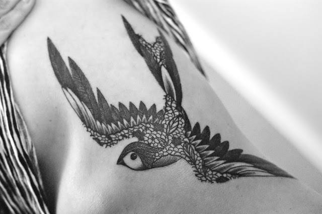 French tattoo artist Dodie creates a swallow bird tattoo design with lace patterns to make a girly tattoo design