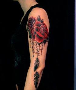 Lace and roses become a feminine dreamcatcher tattoo design in this tattoo for women by Dodie