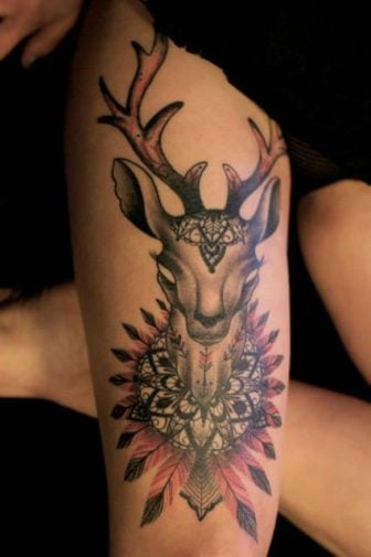 Tattoo artist Dodie adds spiritual symbolism to this tattoo of a deer by adding mandalas and feathers