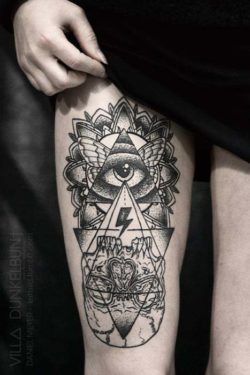 A human eye in a triangle with butterfly wings and a mandala flower visualizes an upside down skull in this tattoo by Daniel Meyer