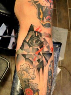 A human eye peers out from between cubist shapes in this artistic tattoo by Marcin Surowiec