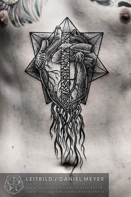 A human heart encased in sacred geometry sets down roots in this black ink tattoo by Daniel Meyer