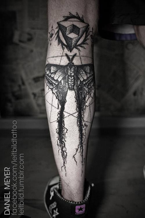 A moth falls to tatters after being caught in a sacred geometry web in this tattoo by Daniel Meyer