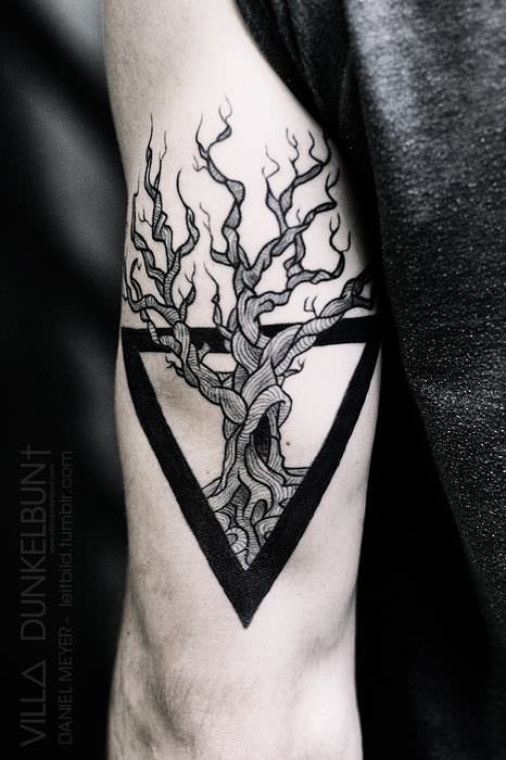 A tree of life grows from a chalice triangle in this spiritual and symbolic tattoo by Daniel Meyer