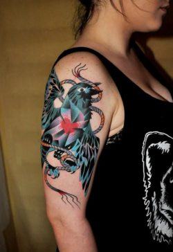 An abstract bird has a cubist heart in this artistic arm tattoo by Marcin Surowiec