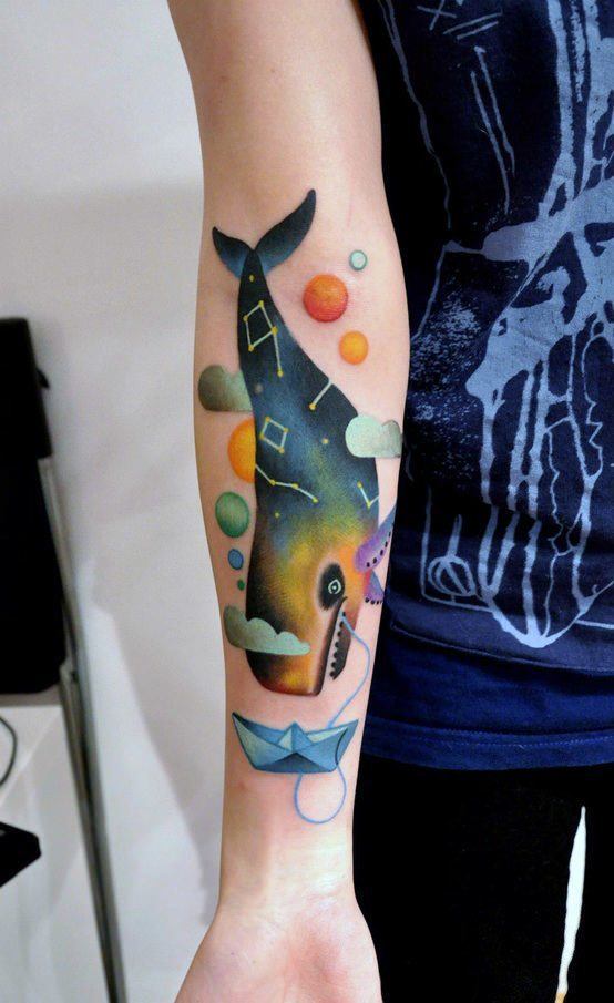An abstract whale with constellations on its skin falls from the sky in this artistic tattoo by Marcin Surowiec