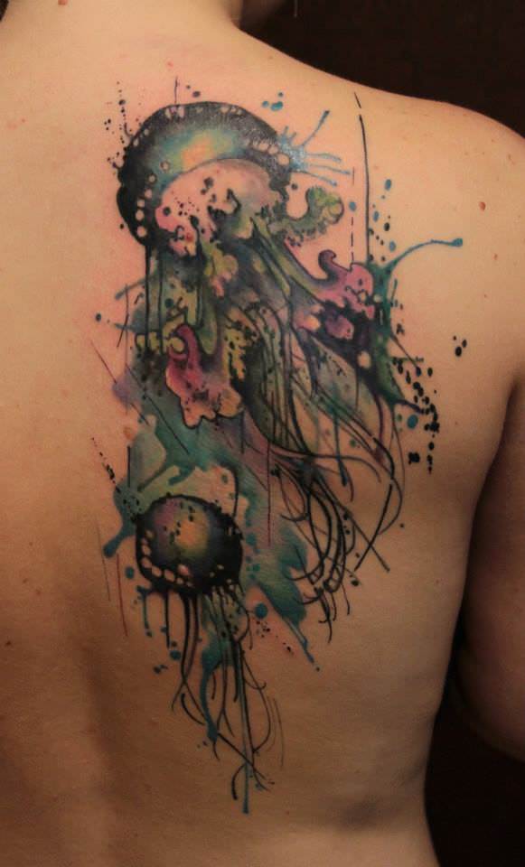 Tattoo artist Gene Coffey creates an artistic body art design of jellyfish in a splatter and watercolor style