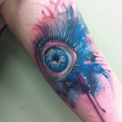 Tattoo artist Mel Wink combines realism and watercolor painting in this artistic tattoo of a womans eye