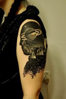 This tattoo by Marcin Surowiec boasts a surrealist scene with cubist icebergs inside the silhouette of a man