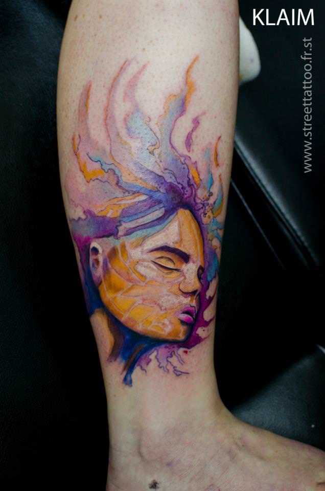 A beautiful girl floats in purple and yellow ink in this artistic porrait tattoo by French artist KLAIM