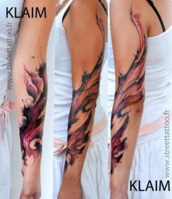 Artistic swirls of paint climb this girls arm in this watercolor fantasy tattoo by French arist KLAIM