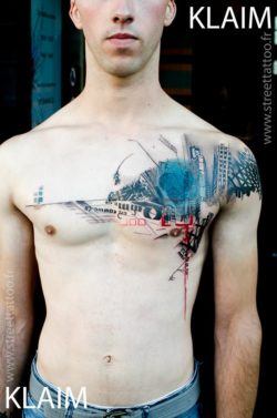 Tattoo artist KLAIM creates a cityscape street tattoo that is designed to work with the shape of his clients body