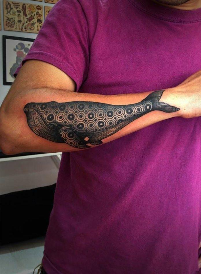 A whale wears geometric patterns in this black ink nature tattoo by Karolina Bebop
