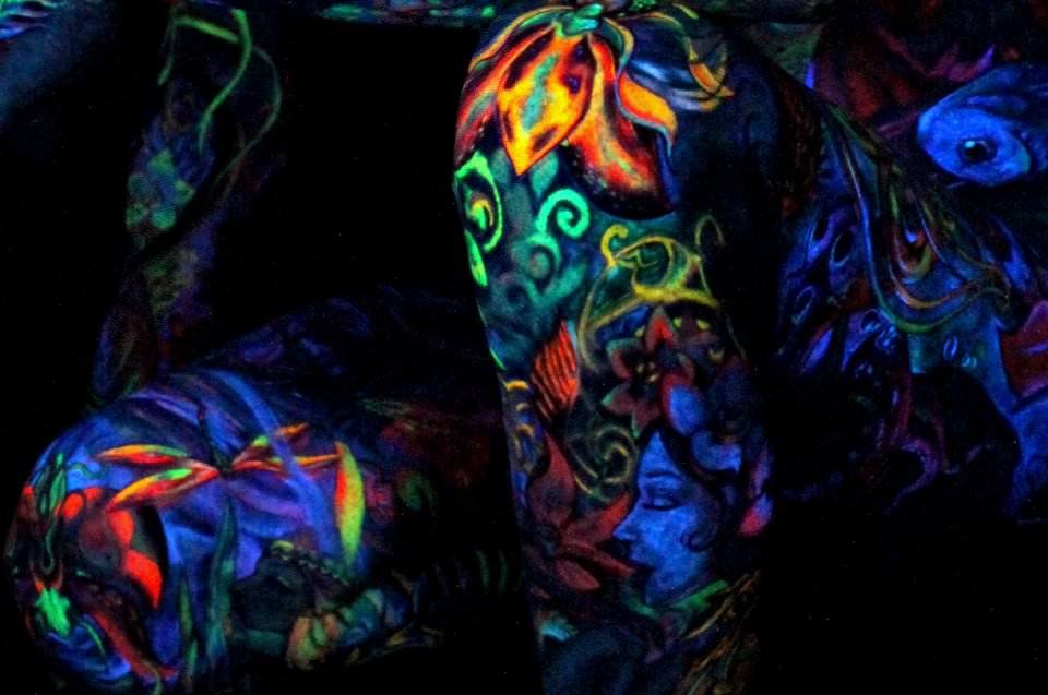 Symbols of beauty, life and nature abound in Glowrious George's UV tattoo bodysuit