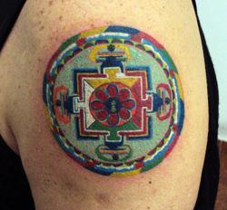 The spiritual significance of this sacred geometry mandala tattoo lies in its use of traditional colors and shapes