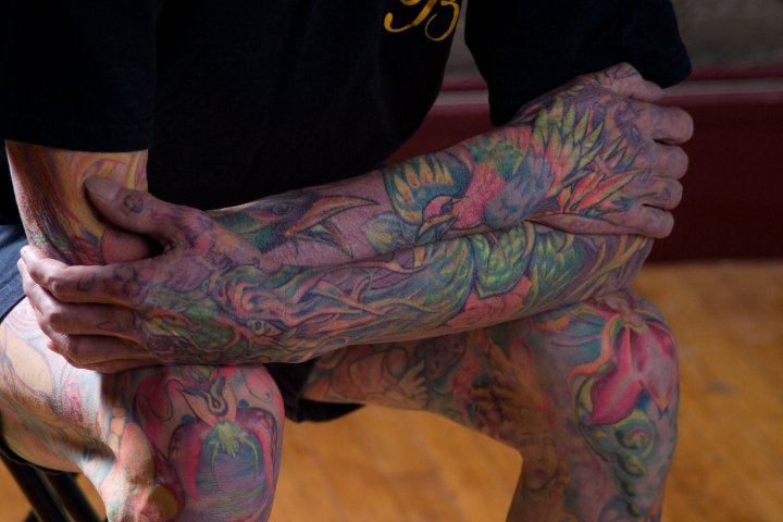 This is an example of Glowrious Georges arm tattoos in daylight. The birds are brightly colored but are dull compared to when viewed under blacklight.