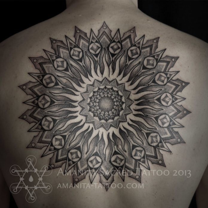 This solar mandala tattoo by Amanita is built up with patterns that are traditionally used to represent the sun