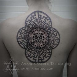 This stunning back tattoo by Mike Amanita uses geometric and organic shapes to create an insterstellar feeling