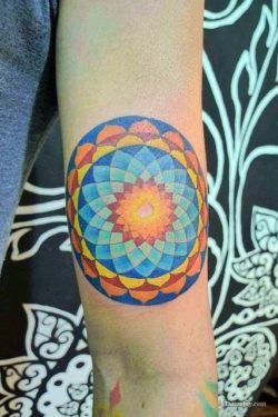 Using mostly primary colors, this flower of life mandala tattoo is friendly and fun.